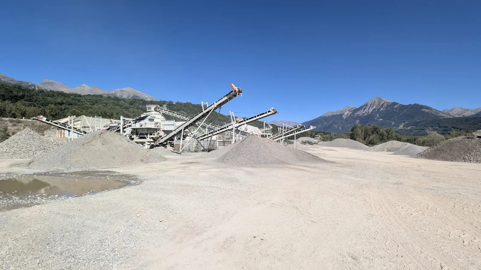 L’installation de traitement des granulats de la carrière de Saint-Julien-en-Champsaur, ses stocks de sables et graviers et le massif du Champsaur en arrière-plan